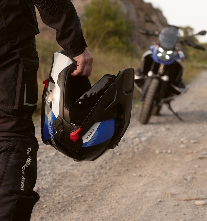 Eine Person hält einen Motorradhelm in der Hand.