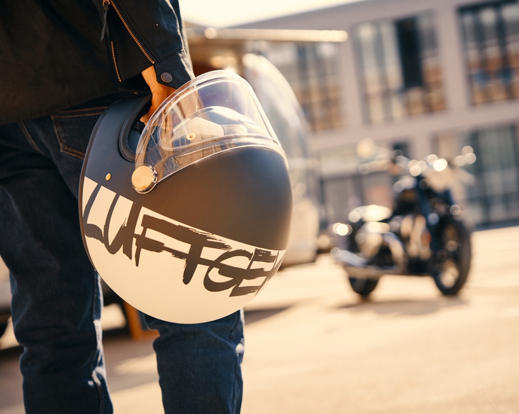 Person hält einen Motorradhelm